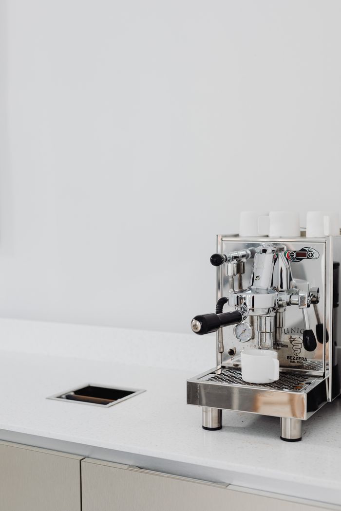 Stainless steel semi-automatic espresso machine on a kitchen counter (generic illustration)